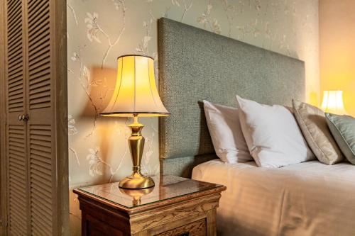 a lamp on a table next to a bed at Best Western Walton Park Hotel in Clevedon