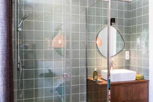 une salle de bain avec une douche avec un lavabo et un miroir dans l'établissement Les Apparts de Charly-Superbe duplex dans un hotel particulier, parking privé gratuit, à La Rochelle