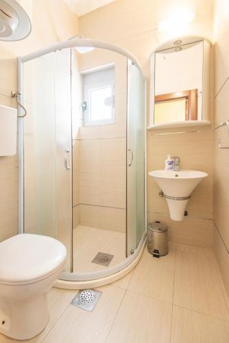 a bathroom with a shower and a toilet and a sink at Gemma di Cattaro Apartments in Kotor