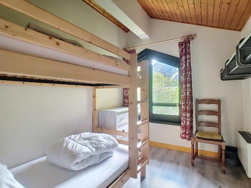 - une chambre avec 2 lits superposés et une chaise dans l'établissement APPARTEMENT DUPLEX SPACIEUX - SAINT JEAN D'AULPS STATION - PIED DES PISTES - 9 Personnes - RELAIS D13, à Saint-Jean-dʼAulps