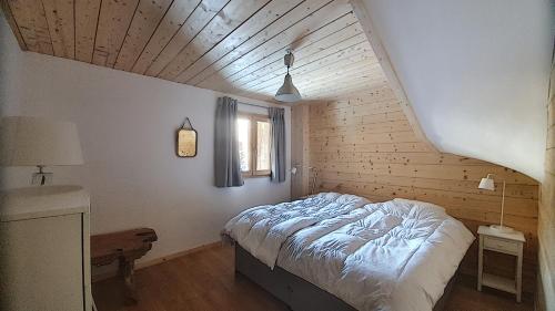 um quarto com uma cama e uma janela em CHALET NEUF -SAINT JEAN D'AULPS STATION 12 PERSONNES - CIMES C6 em Saint-Jean-dʼAulps