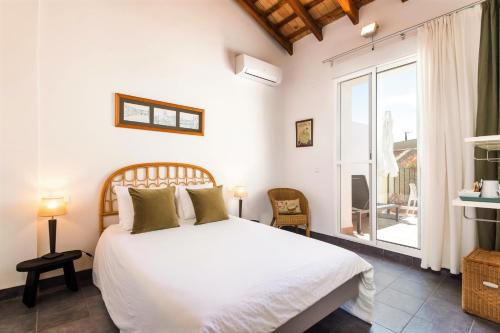 a bedroom with a large white bed and a window at Casa Sibarita in Rafelguaraf