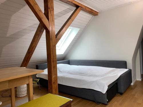 een slaapkamer op zolder met een bed en een tafel bij 2-Zimmer-Apartment in München in München