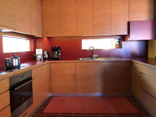 a kitchen with wooden cabinets and a sink at Villa with swimming pool and tennis/basketball court in Theológos