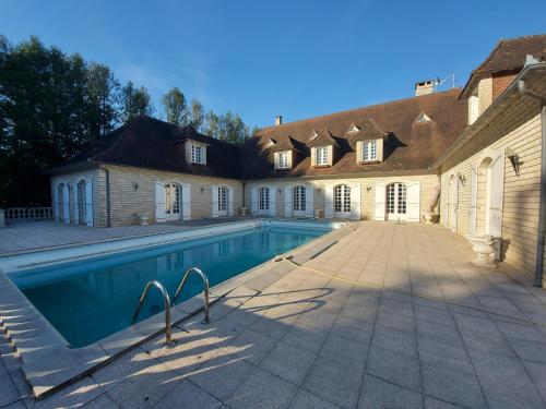 a swimming pool in front of a house at Le Belvédère in Thiviers