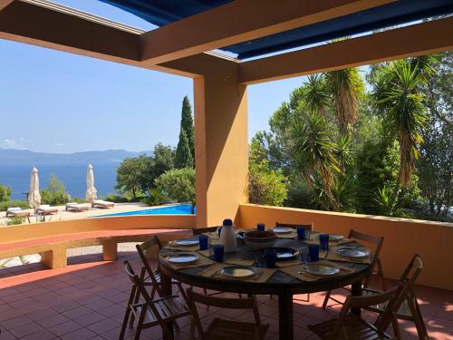 a dining room with a table and chairs on a patio at Villa with swimming pool and tennis/basketball court in Theológos