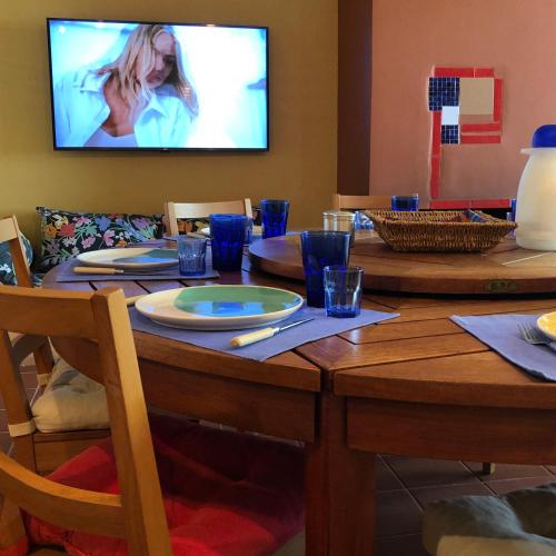 a dining room table with a television on the wall at Villa with swimming pool and tennis/basketball court in Theológos