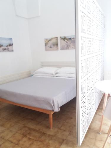 ein Schlafzimmer mit einem Bett in einem weißen Zimmer in der Unterkunft Casa Vacanze Mazzini in Santa Maria al Bagno