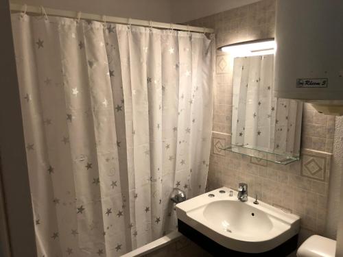 y baño con cortina de ducha y lavamanos. en Soleil Levant, en Villers-sur-Mer