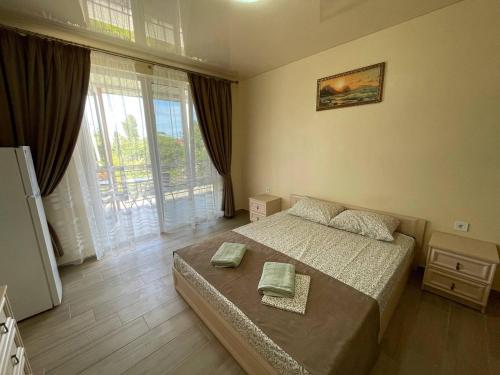 a bedroom with a bed and a large window at ZAKAT in Zatoka