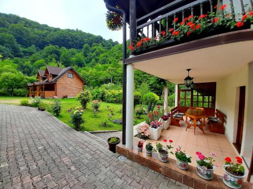 een patio met bloemen en een huis met een tuin bij Janjske otoke - smještaj na selu (Milorad Piljić) in Šipovo