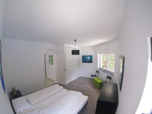 Un dormitorio blanco con una cama y un escritorio. en Casa Verde, en Feteira