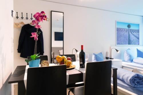 een eetkamer met een tafel en een spiegel bij HITrental Allmend Comfort Studios in Luzern