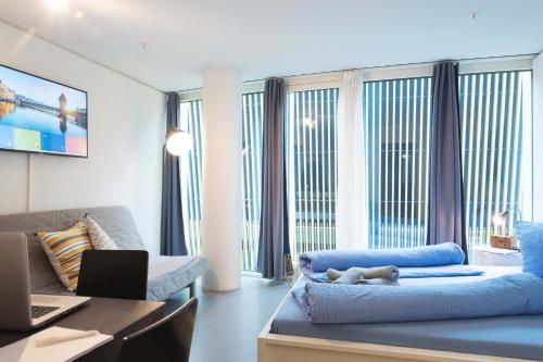 a living room with a dog laying on a blue couch at HITrental Allmend Standard Studios in Luzern