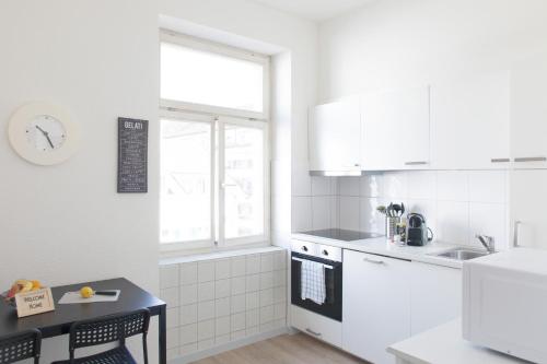 eine weiße Küche mit einer Spüle und einem Herd in der Unterkunft HITrental Seefeld - Kreuzstrasse Apartments in Zürich