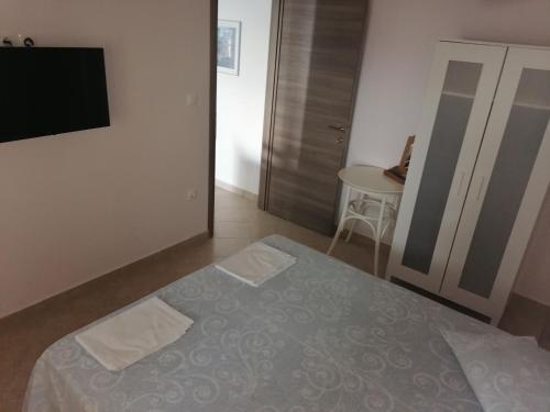 a bedroom with a bed and a flat screen tv at Porto Almira Beachfront House in Nikiti