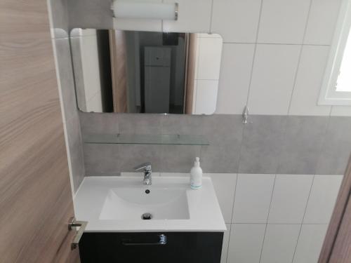 a bathroom with a sink and a mirror at Porto Almira Beachfront House in Nikiti
