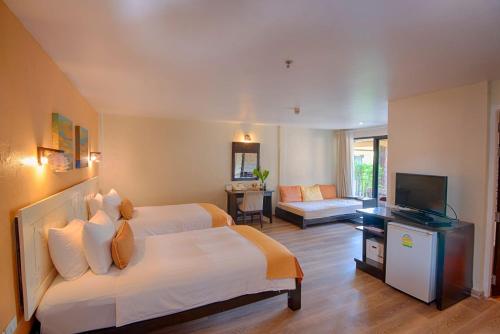 a hotel room with two beds and a television at Vacation Village Phra Nang Inn - SHA Extra Plus in Ao Nang Beach