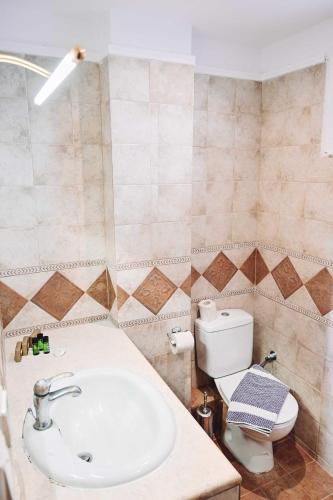 a bathroom with a sink and a toilet at JJ Rooms luxury apartments in Kallithea Halkidikis