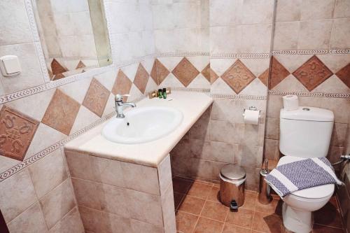 a bathroom with a sink and a toilet at JJ Rooms luxury apartments in Kallithea Halkidikis