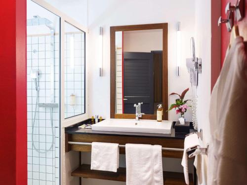 y baño con lavabo y espejo. en Hotel Mercure Kourou Ariatel, en Kourou