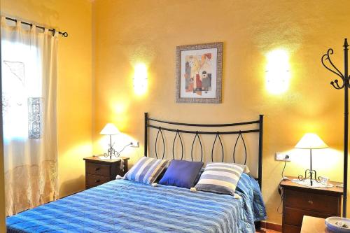 a bedroom with a bed with a blue comforter at Finca Sant Vicenç 022 by Mallorca Charme in Muro