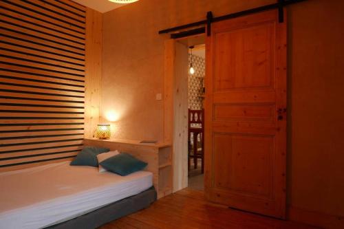 a bedroom with a bed and an open door at Joli appartement confortable rénové style cosy in Saint-Martin-de-la-Porte