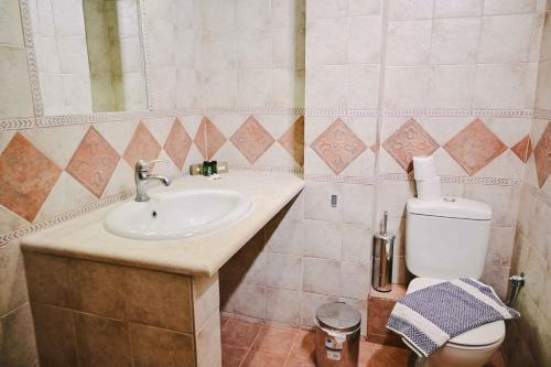 a bathroom with a sink and a toilet at JJ Rooms luxury apartments in Kallithea Halkidikis