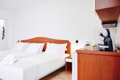 a bedroom with two beds and a telephone at JJ Rooms luxury apartments in Kallithea Halkidikis