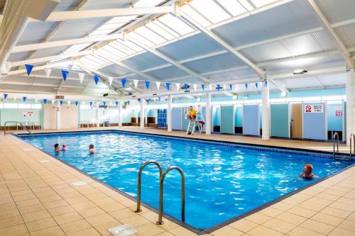 a large indoor swimming pool with people in it at Seahawk Lodge in Whitley Bay