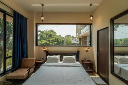 a bedroom with a bed and a large window at Triose Boutique Hotel Lonavala in Lonavala