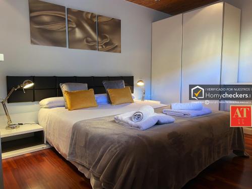 een slaapkamer met een groot bed en handdoeken bij HomyAT Atico Prior, Plaza Mayor in Salamanca