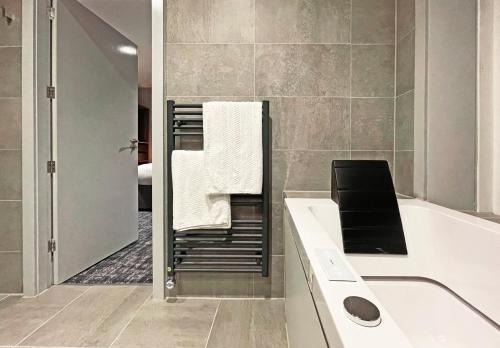 a bathroom with a sink and a bath tub with towels at 1820 Boutique Rooms & Suites in Blackpool