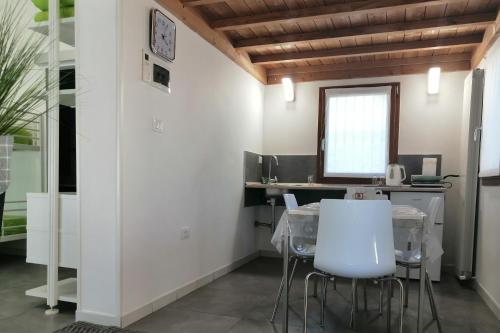 a kitchen with white walls and a table and chairs at GreenColors DEPENDANCE in Campalto