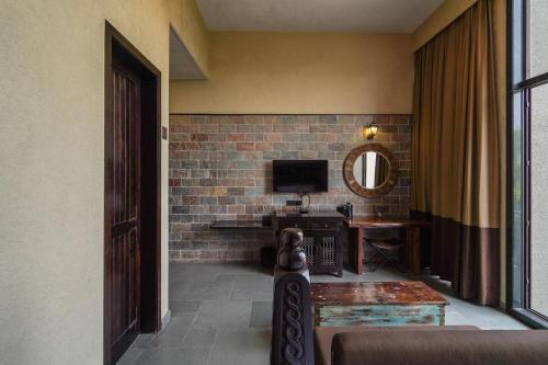 a room with a television and a desk with a television at Triose Boutique Hotel Lonavala in Lonavala