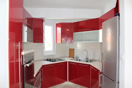 a kitchen with red cabinets and a sink at Tomislav in Makarska