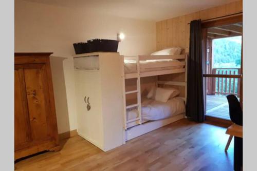 a bedroom with bunk beds in a room with a balcony at Rev2 Montagne in La Bresse