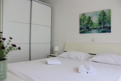 uma cama branca com duas toalhas brancas em Tomislav em Makarska