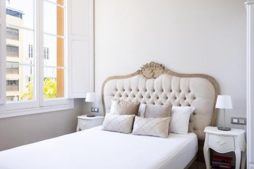1 dormitorio blanco con 1 cama blanca grande con almohadas en Central Lofts, en Santa Cruz de Tenerife