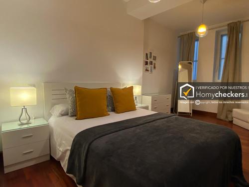 a bedroom with a large bed with yellow pillows at HomyAT Prior Romo, Plaza Mayor in Salamanca