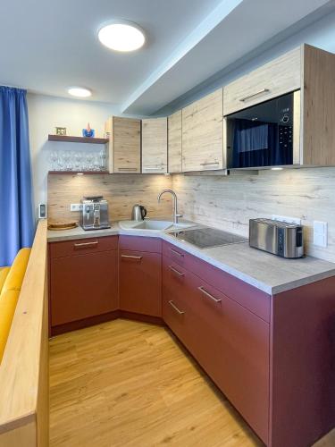 a kitchen with brown cabinets and a sink and a counter at Landhaus Renata - Wendelstein in Bayrischzell