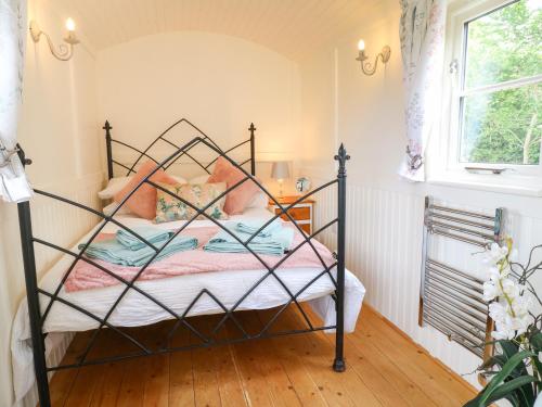 um quarto com uma cama com uma estrutura de metal em Shepherds Hut em Rugeley