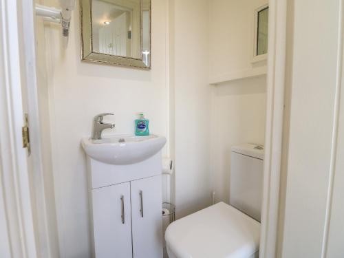a small bathroom with a sink and a toilet at Shepherds Hut in Rugeley