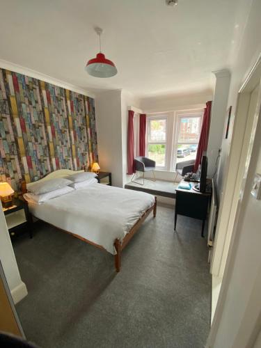 a bedroom with a bed and a living room at The Sandhaven in Swanage