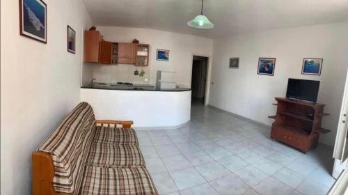 ein Wohnzimmer mit einem Sofa und einer Küche in der Unterkunft Lopadusa trilo 1 in Lampedusa