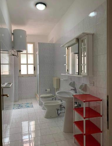 ein Badezimmer mit einem Waschbecken, einem WC und einem Spiegel in der Unterkunft Lopadusa trilo 1 in Lampedusa