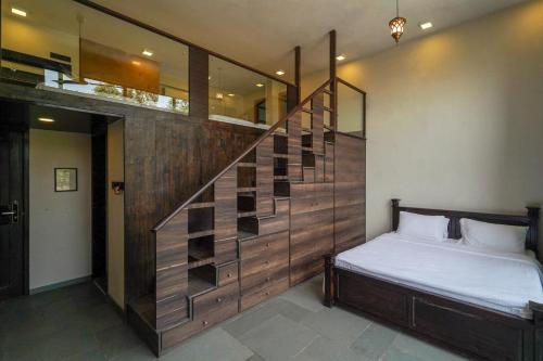 a bedroom with a bed and a wooden staircase at Triose Boutique Hotel Lonavala in Lonavala