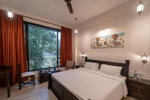 a bedroom with a large bed and a large window at Triose Boutique Hotel Lonavala in Lonavala