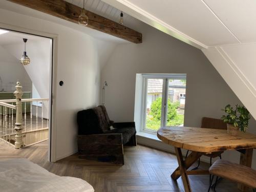 a room with a table and a chair and a window at So-Hum in Den Burg