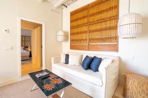 a living room with a white couch and a table at Hotel La Torre del Canonigo - Small Luxury Hotels in Ibiza Town